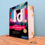 Fotografie des Buchs Adobe InDesign CC, das umfassende Handbuch vor blauem Hintergrund